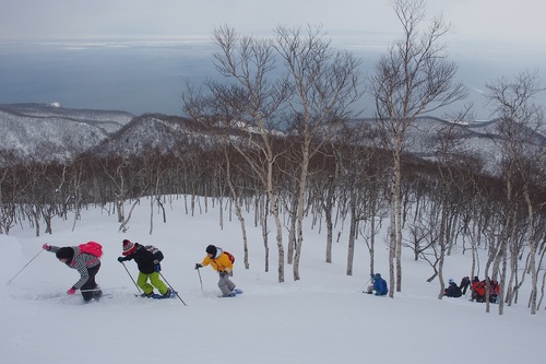 雪に覆われた斜面を苦労しながら登る羅臼町の小学生（2019年2月撮影）